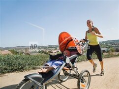 A woman jogging while pushing her baby in the stroller