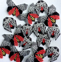 More than a dozen spotted lanternflies crafted from origami