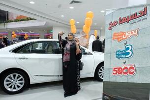 A Saudi woman taking a selfie at the auto show