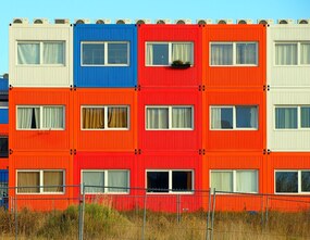A row of candy-color, three-story container homes